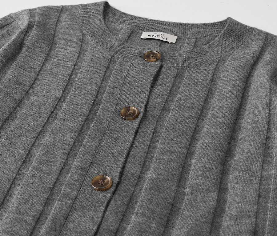 Gros plan sur un cardigan gris boutonné.