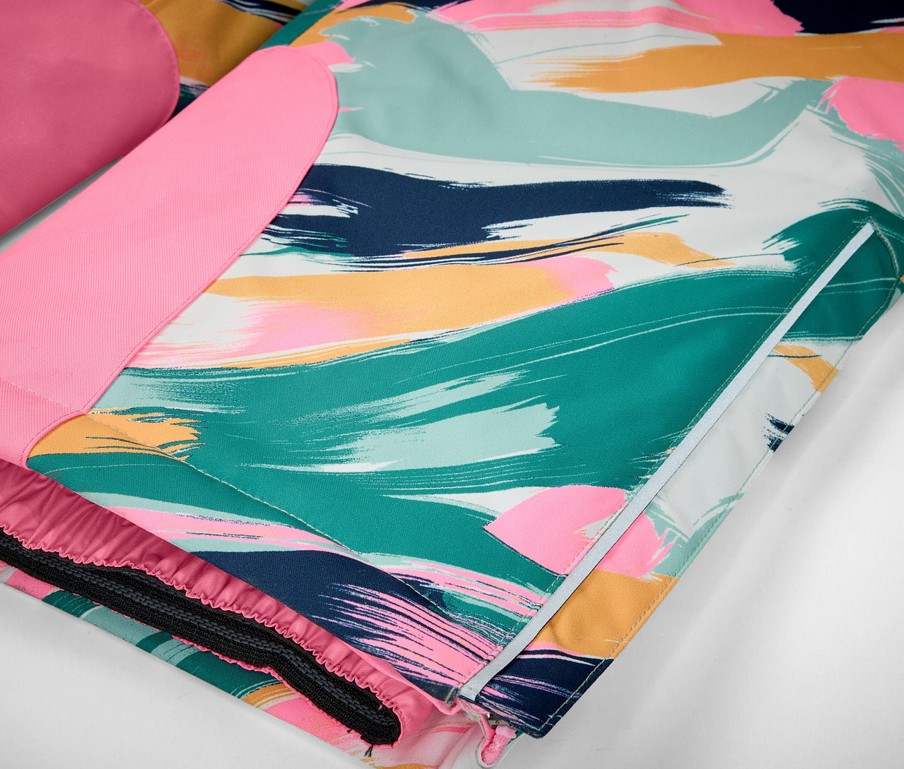 Détail d'une veste avec des coups de pinceau colorés dans les tons de vert, bleu, rose et jaune.