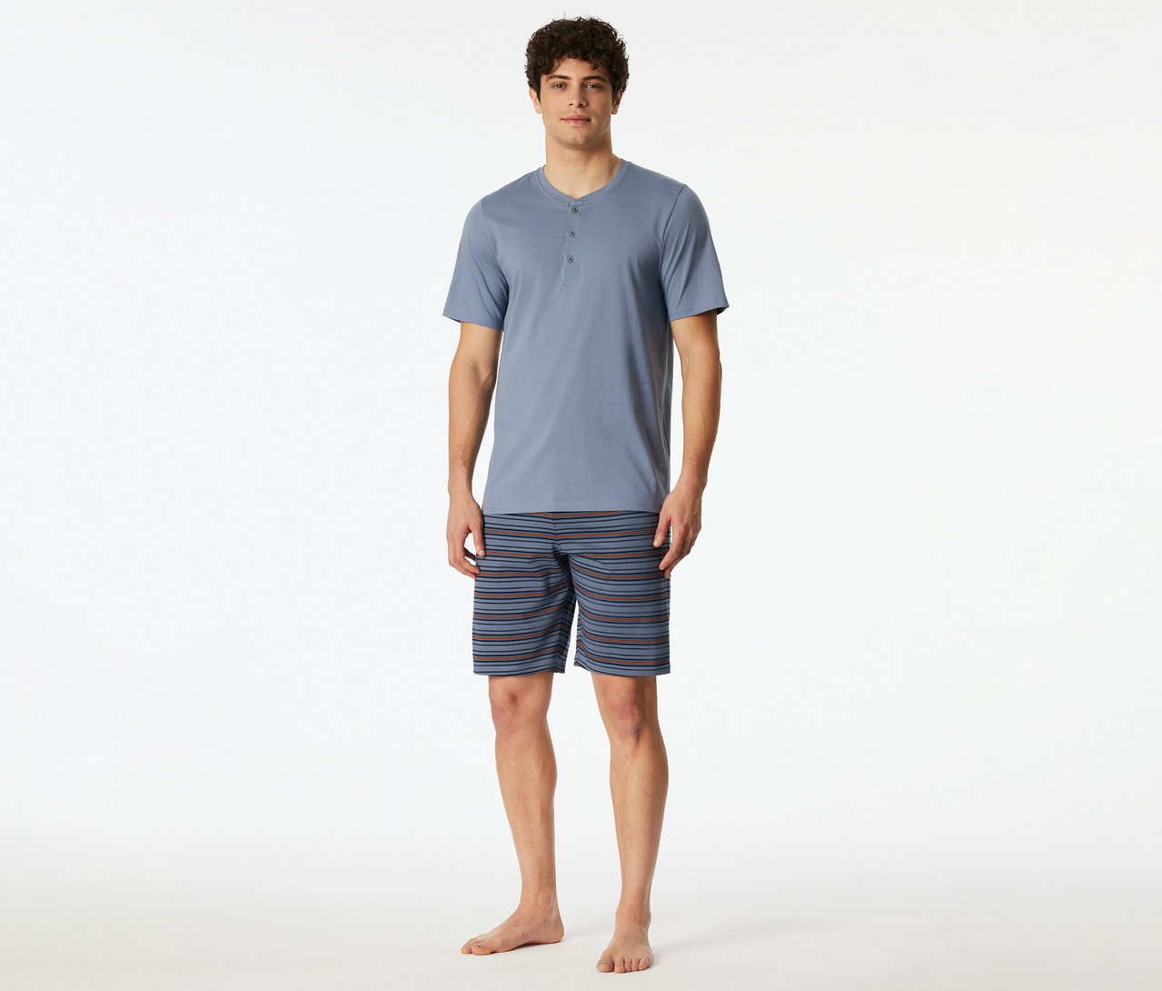 Homme portant un set shorty SCHIESSER bleu-gris avec un haut Henley à manches courtes et un short rayé.