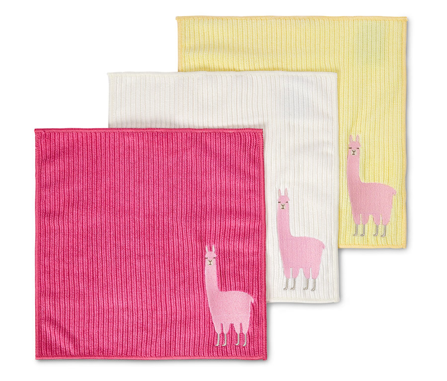 Trois débarbouillettes roses, blanches et jaunes sont superposées, chacune avec un lama brodé.