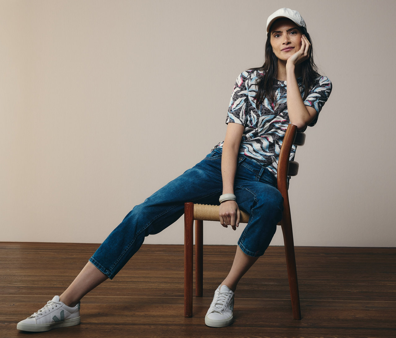 Une femme assise sur une chaise porte un t-shirt manches courtes CECIL bleu et un jean CECIL « Scarlett ».