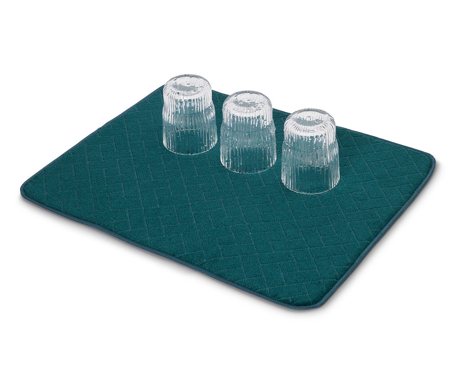 Trois verres vides retournés sont posés sur un tapis égouttoir turquoise à motif losanges.