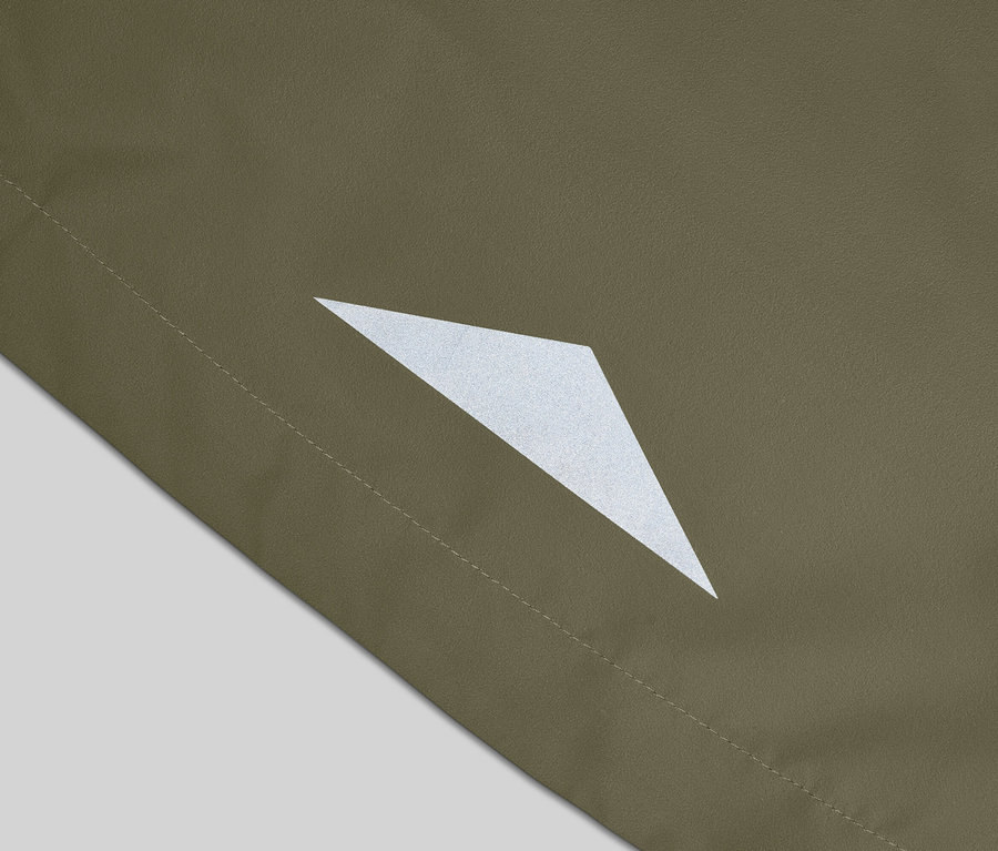 Gros plan d'un tissu vert olive avec un détail triangulaire réfléchissant et une couture.