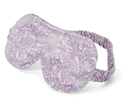 Gros plan d'un masque de sommeil violet avec un motif cachemire blanc.