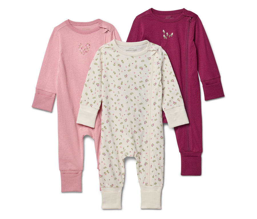 Trois pyjamas pour bébés rose, blanc à motifs floraux et violet sont superposés.