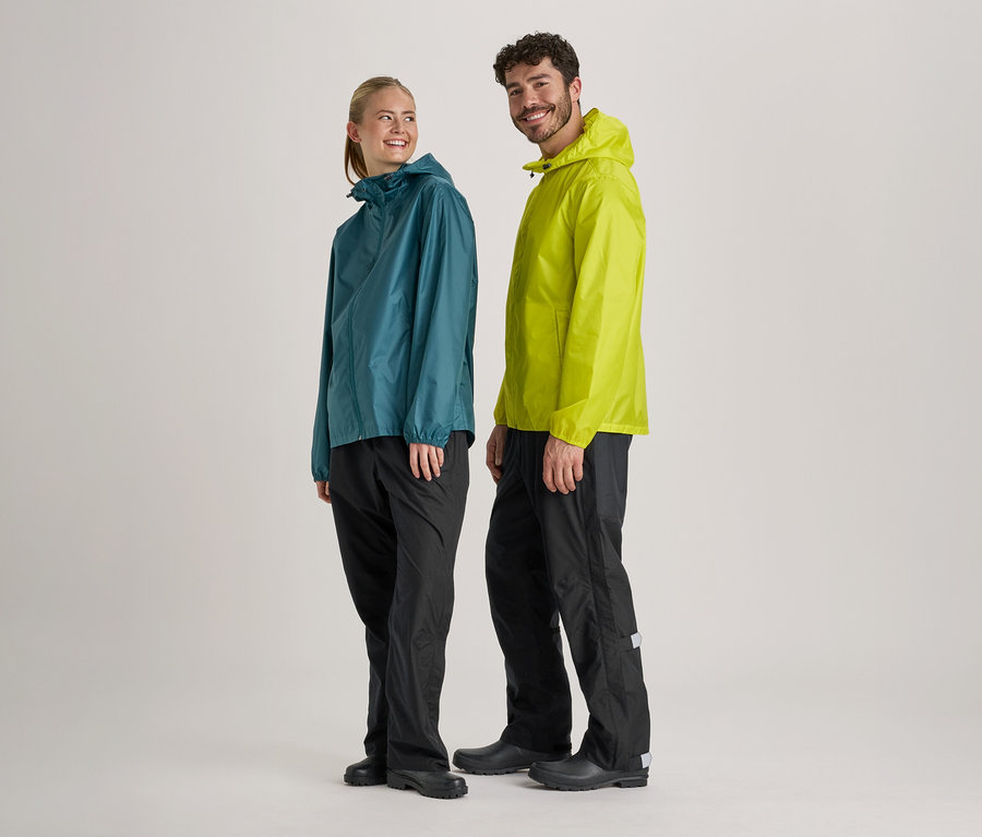 Une femme en imperméable bleu-vert et un homme en imperméable vert clair et pantalon de pluie noir se tiennent côte à côte sur un fond clair.