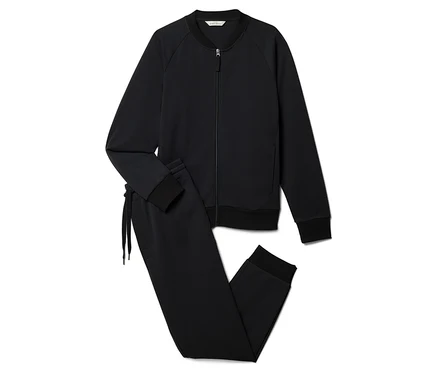 Un survêtement noir composé d'une veste zippée et d'un pantalon à cordon de serrage est posé sur un fond blanc.