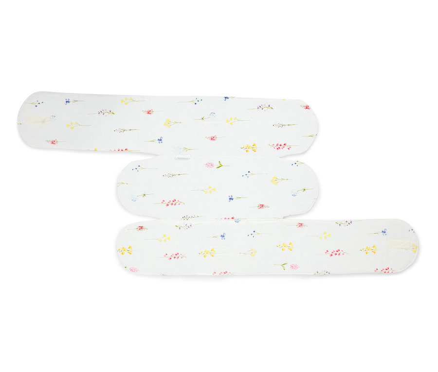 Trois serviettes hygiéniques en tissu blanc à motifs floraux superposées.
