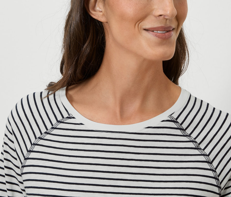 Gros plan d'une femme portant un t-shirt rayé à manches longues.