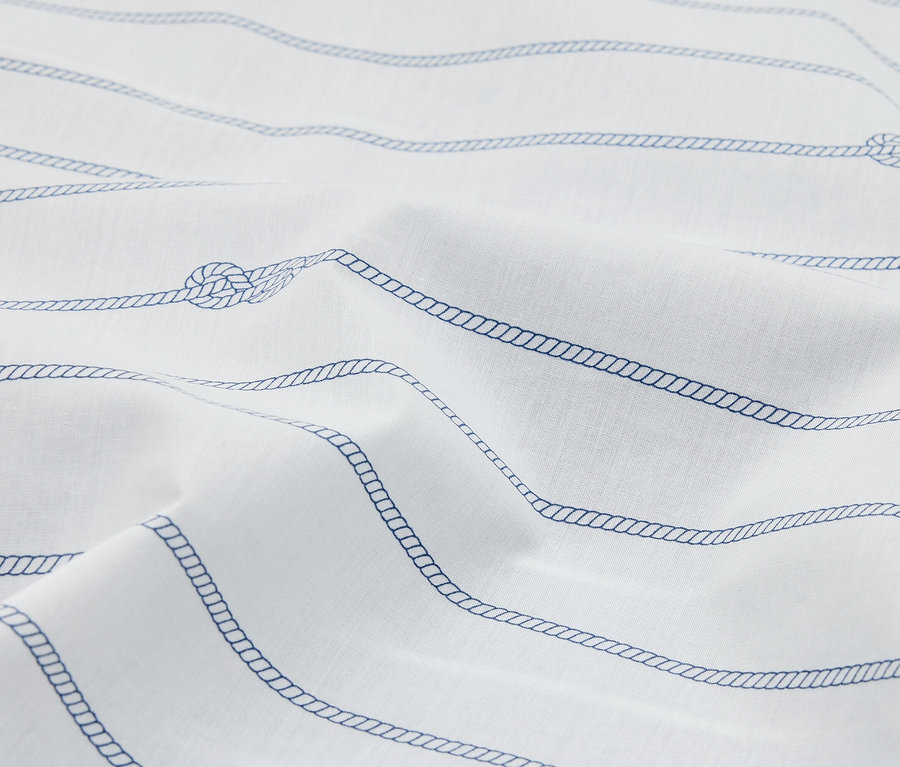 Gros plan sur un tissu blanc à rayures bleues avec motif de corde, disposé en vagues.