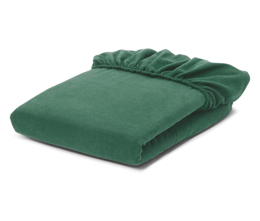 Drap-housse émeraude plié avec des bords élastiques sur fond blanc.