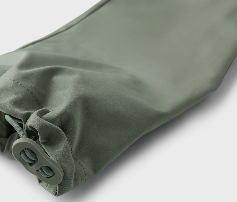 Gros plan sur une manche vert olive avec cordon de serrage.