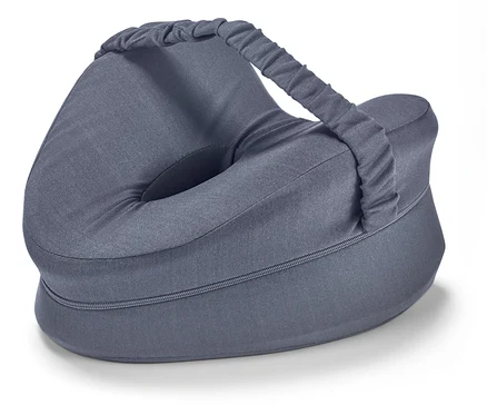 Un coussin gris pour les genoux avec une poignée repose sur une surface blanche.
