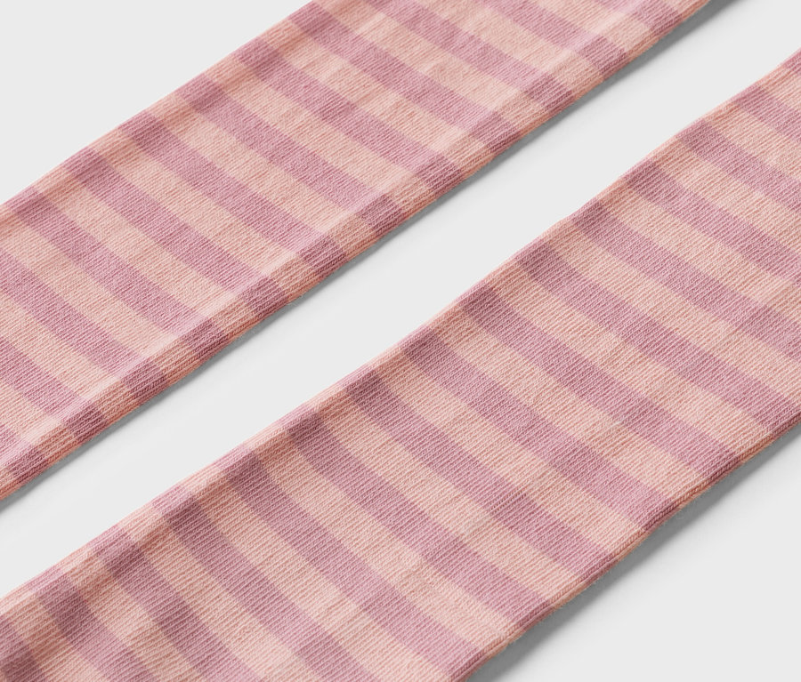 Gros plan de deux chaussettes rayées rose et violet sur fond blanc.