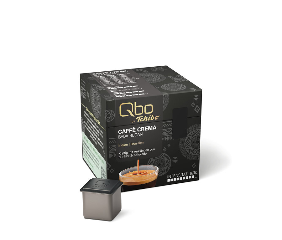 Emballage noir de capsules de café Qbo by Tchibo Caffè Crema Baba Budan, indiquant les origines Inde et Brésil, des notes de chocolat noir et une intensité de 9/10. Une capsule individuelle et un verre de café avec crème sont placés devant.