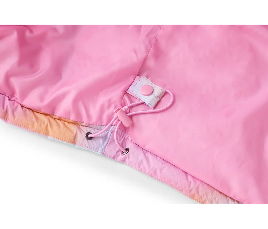 Gros plan sur l'intérieur d'une veste rose, montrant une doublure rose vif et un cordon de serrage avec un stoppeur et des œillets roses. Le bord inférieur de la veste présente un motif dégradé coloré en rose, orange et violet, avec un bouton-pression rose sur une patte en tissu.