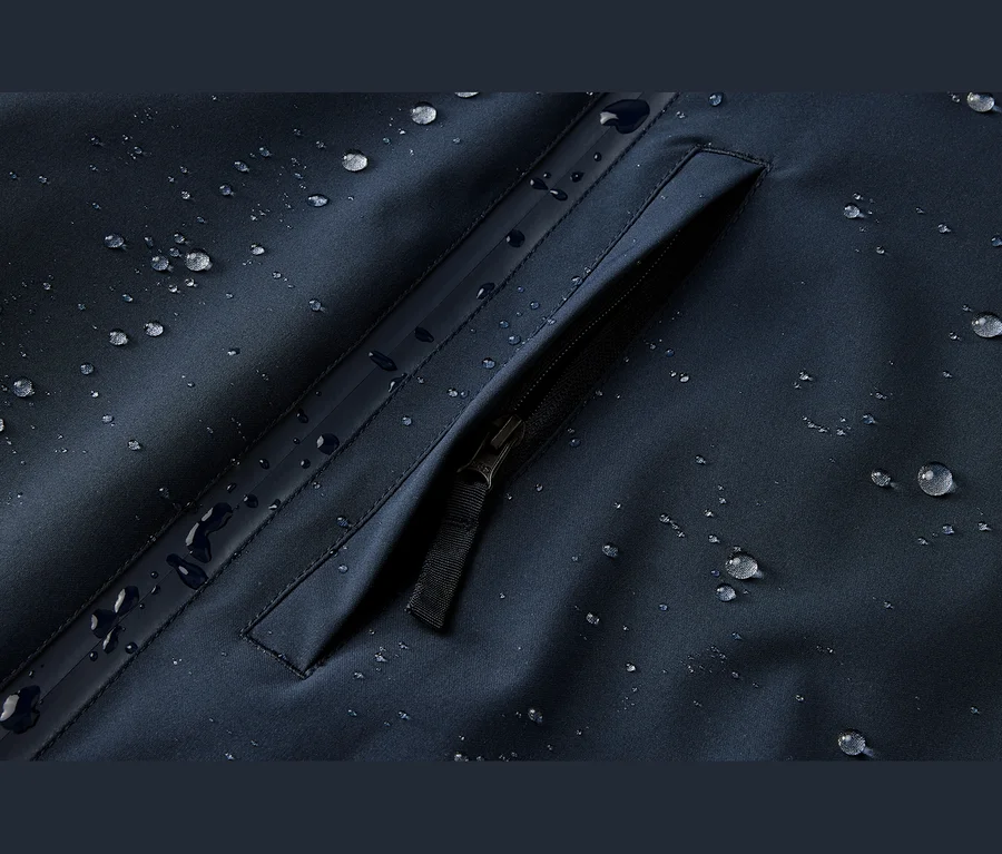Tissu bleu foncé résistant à l'eau avec des gouttelettes d'eau et une poche zippée.