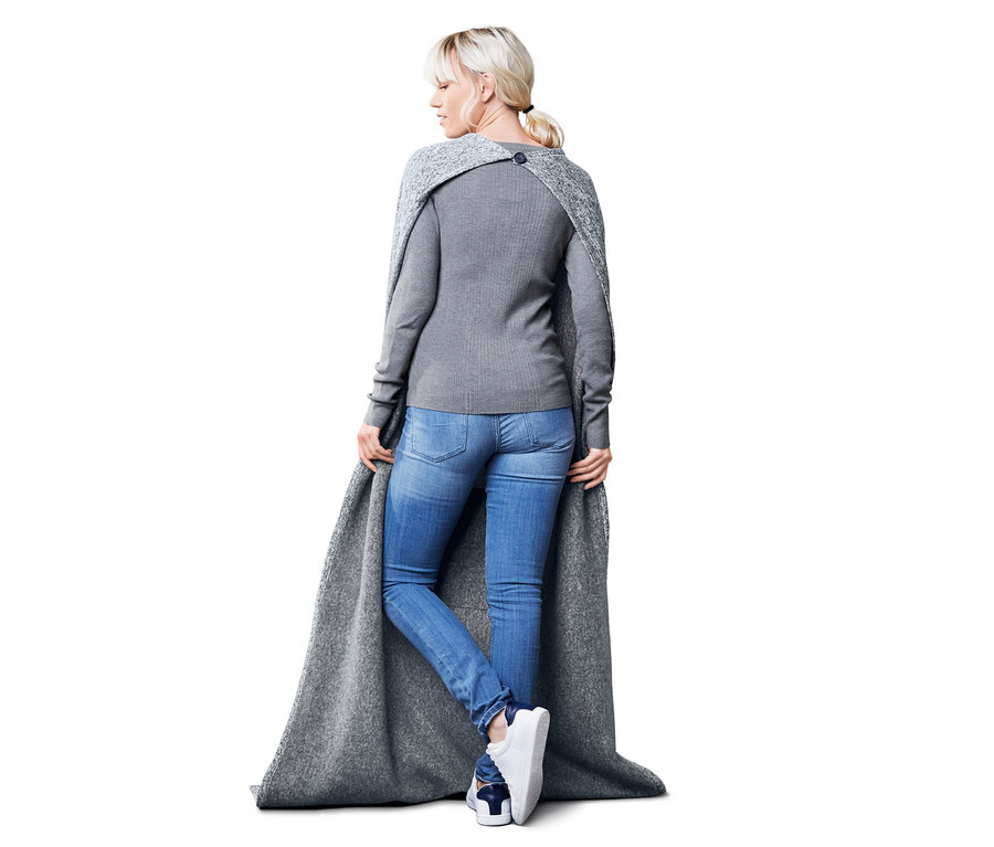Femme vue de dos portant une couverture de voyage.