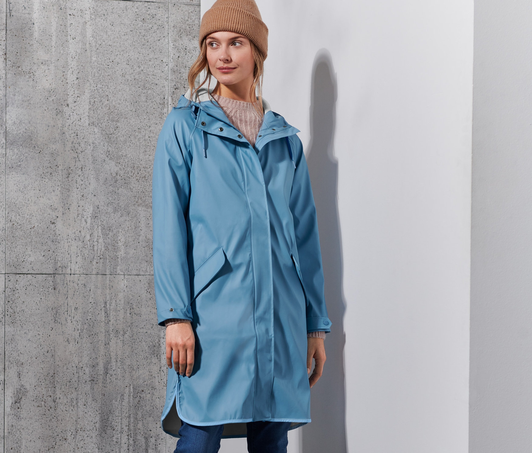 Femme posant dans un parka de pluie « ciré » bleu clair.