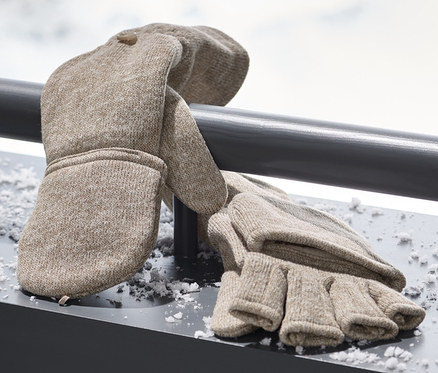Des mitaines avec moufles amovibles en maille polaire beige reposent sur une surface enneigée.