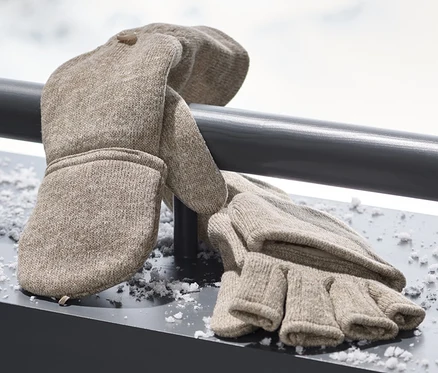 Des mitaines avec moufles amovibles en maille polaire beige reposent sur une surface enneigée.