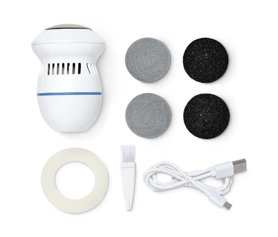Une râpe électrique pour pieds blanche avec fonction d'aspiration, deux embouts gris et deux noirs, une brosse de nettoyage, un câble USB et du papier abrasif.