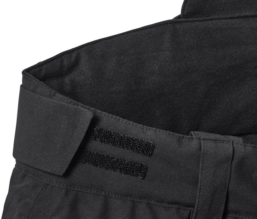 Gros plan sur un pantalon de ski high-tech noir avec une fermeture velcro.