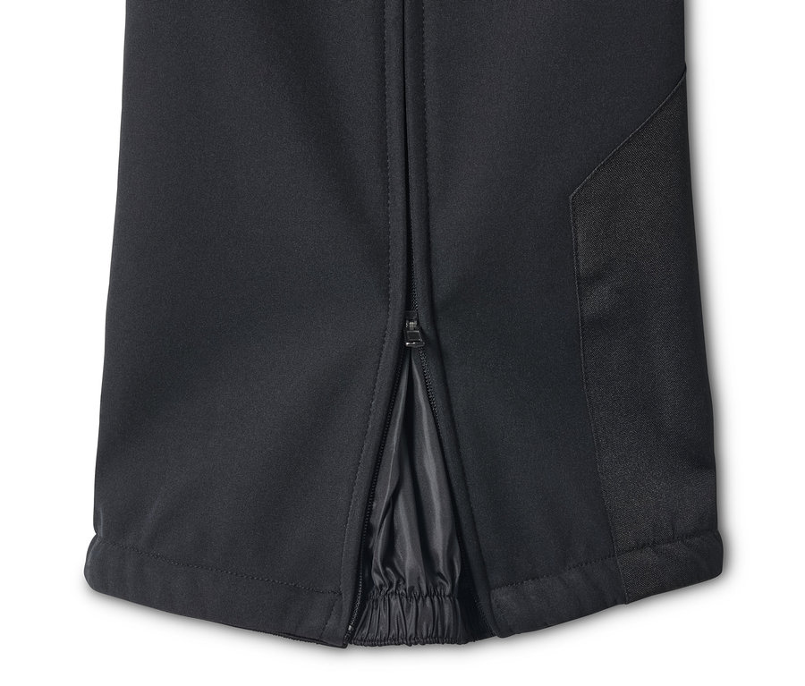 Gros plan sur un pantalon de ski noir avec une fermeture éclair à la cheville.