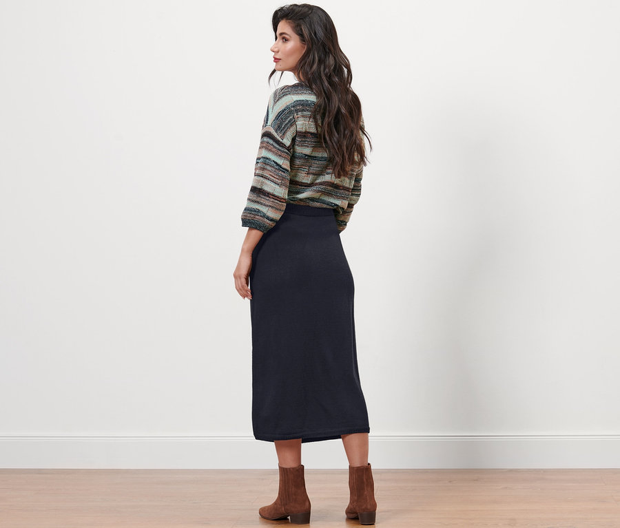 Une femme, vue de dos, porte une jupe tricotée bleu foncé.