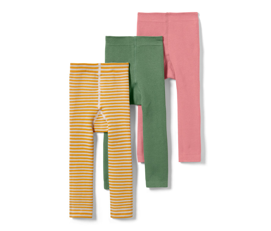 Trois leggings thermiques pour enfant : un rayé orange et blanc, un vert et un rose.