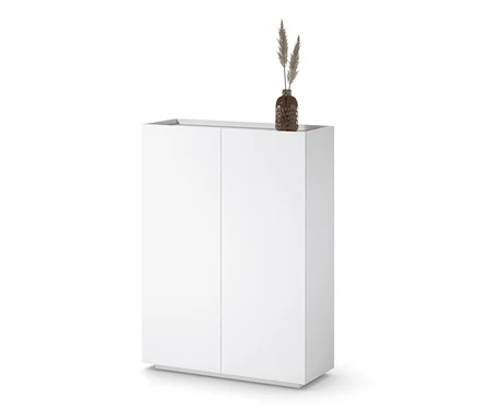 Meuble haut blanc avec un vase contenant de l'herbe dessus.