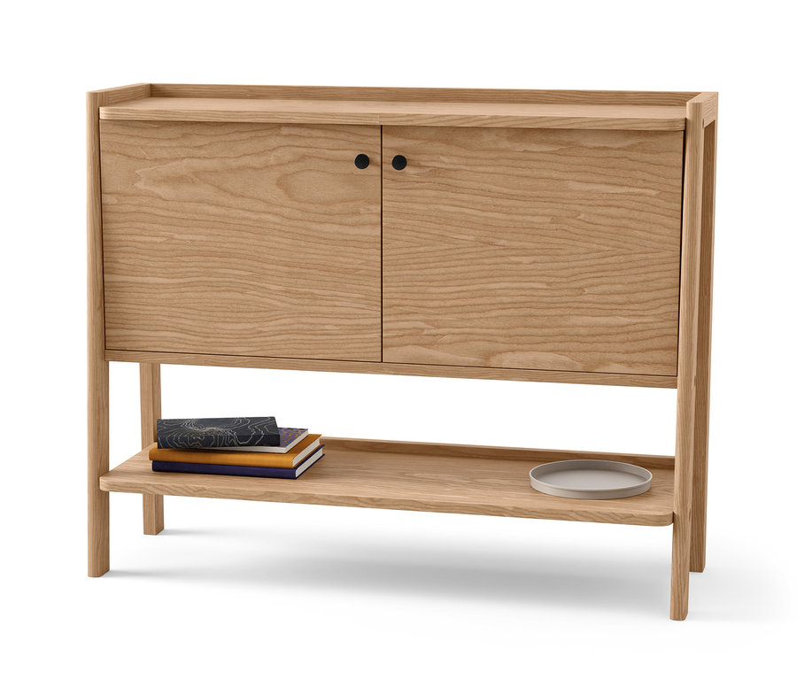 Buffet en bois clair avec deux portes et une étagère avec des livres et une assiette.