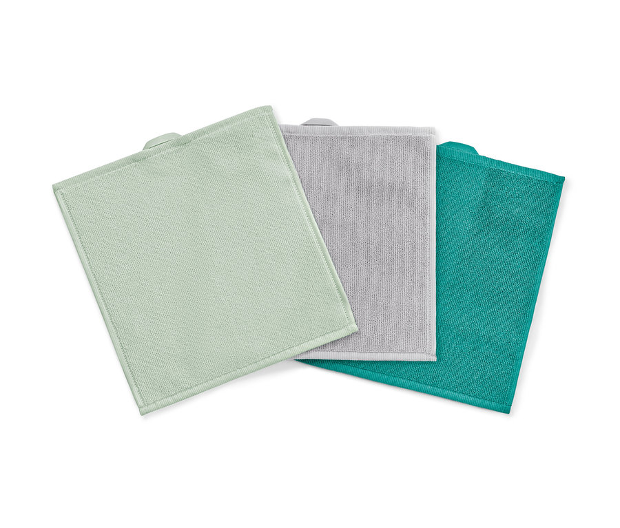 Trois lingettes cosmétiques en microfibre en vert, gris et turquoise sur fond blanc.