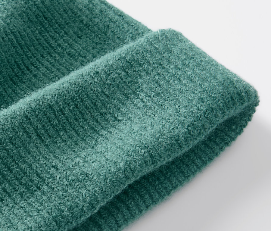 Gros plan d'un bonnet en maille vert.