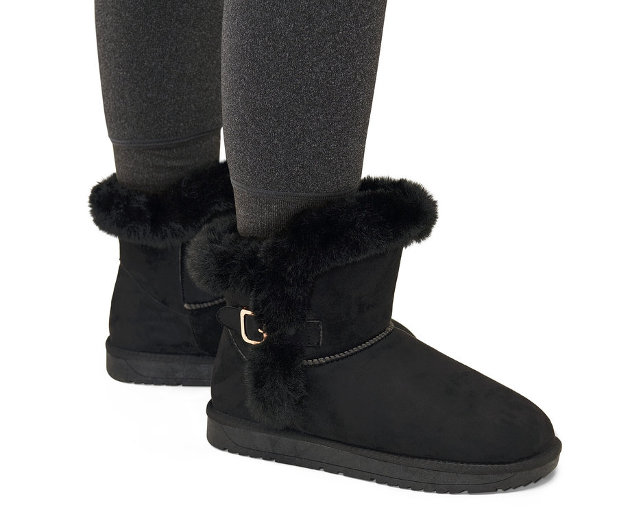 Jambes portant des bottes doublées noires.
