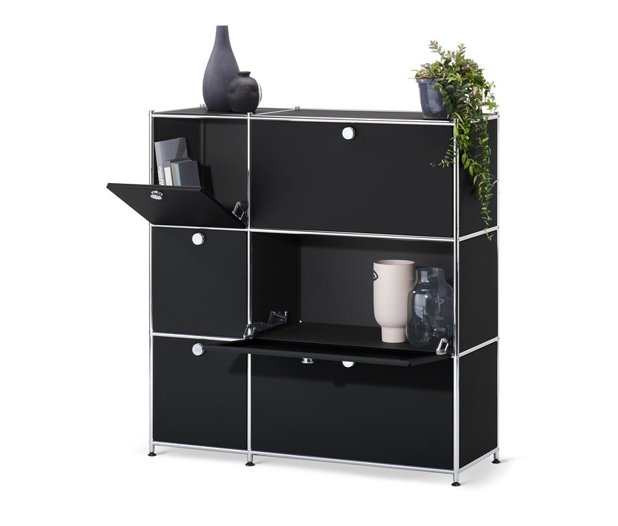 Commode « CN3 » noire avec 6 abattants, dont certains sont ouverts. Des décorations sont posées sur et dans la commode.