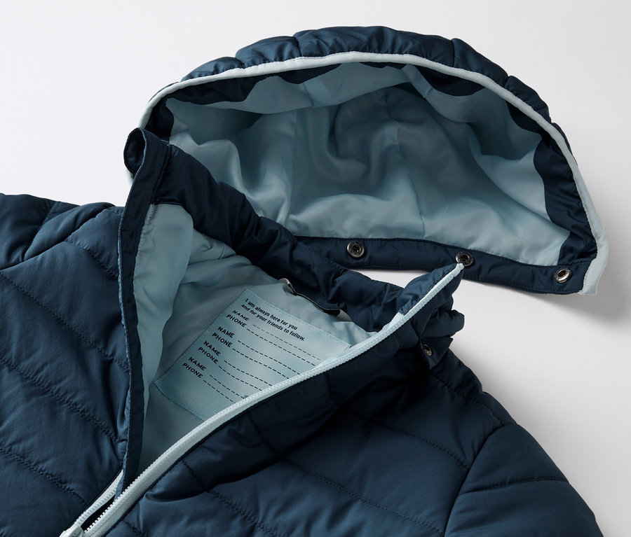 Gros plan sur une veste matelassée pour enfant bleu marine.