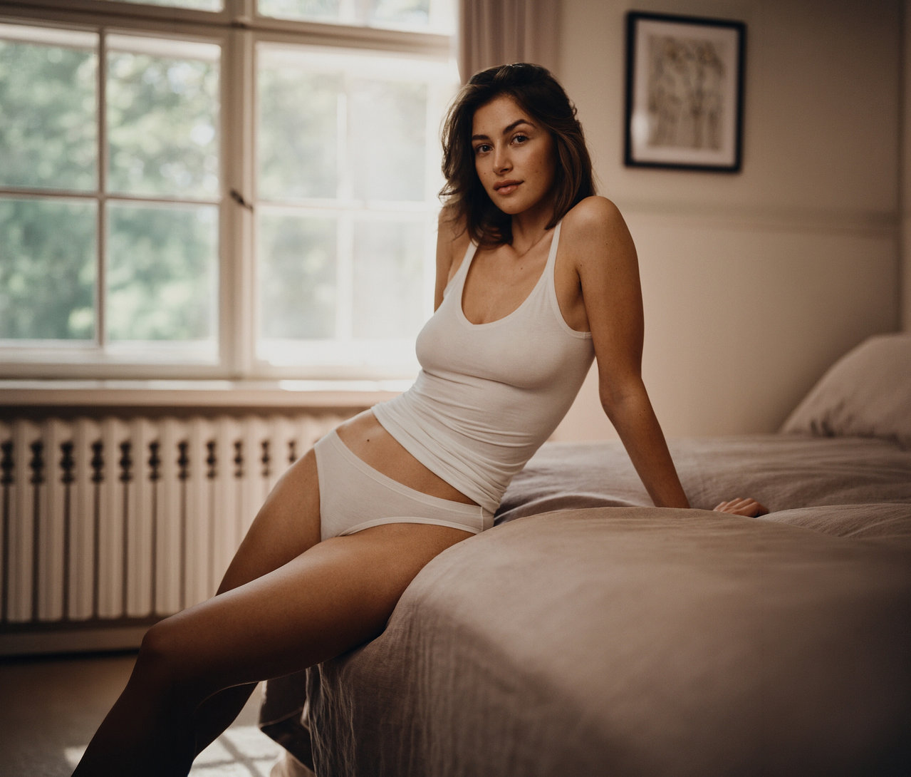 Femme assise sur un lit portant un 2
Tops SCHIESSER, blanc.