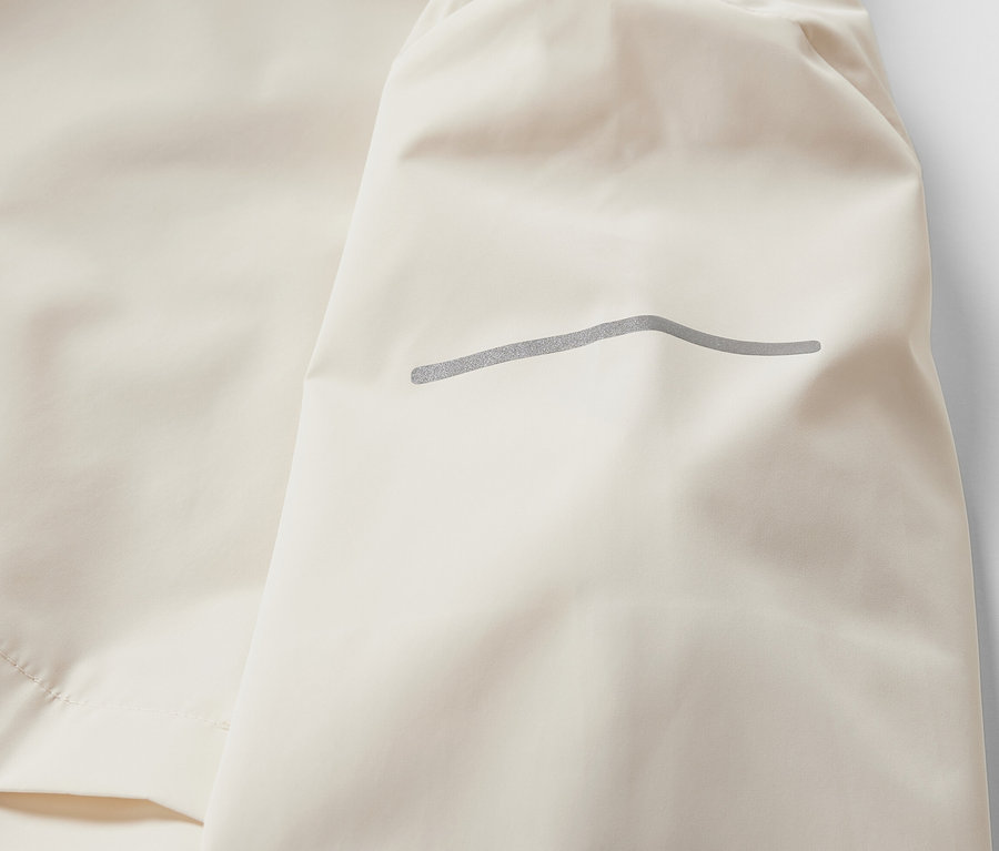 Détail d'une veste de sport coupe-vent crème.