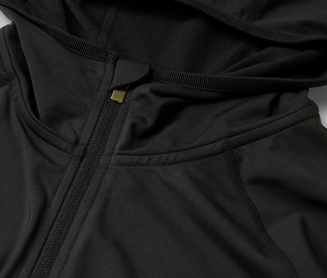 Détail d'un sweat à capuche noir avec fermeture éclair.