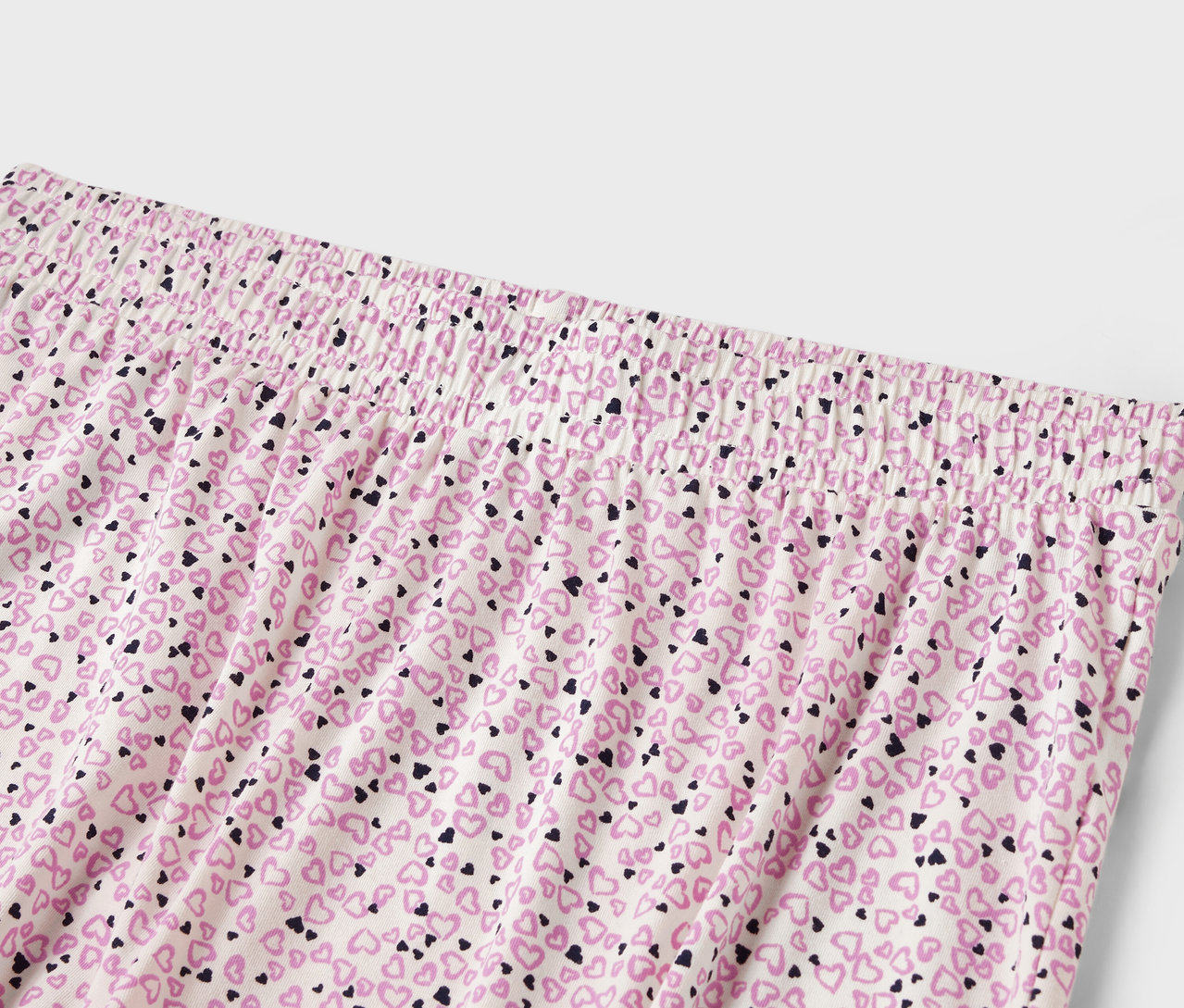 Détail d'un pantalon de femme avec une taille élastique et un imprimé all-over de petits cœurs.