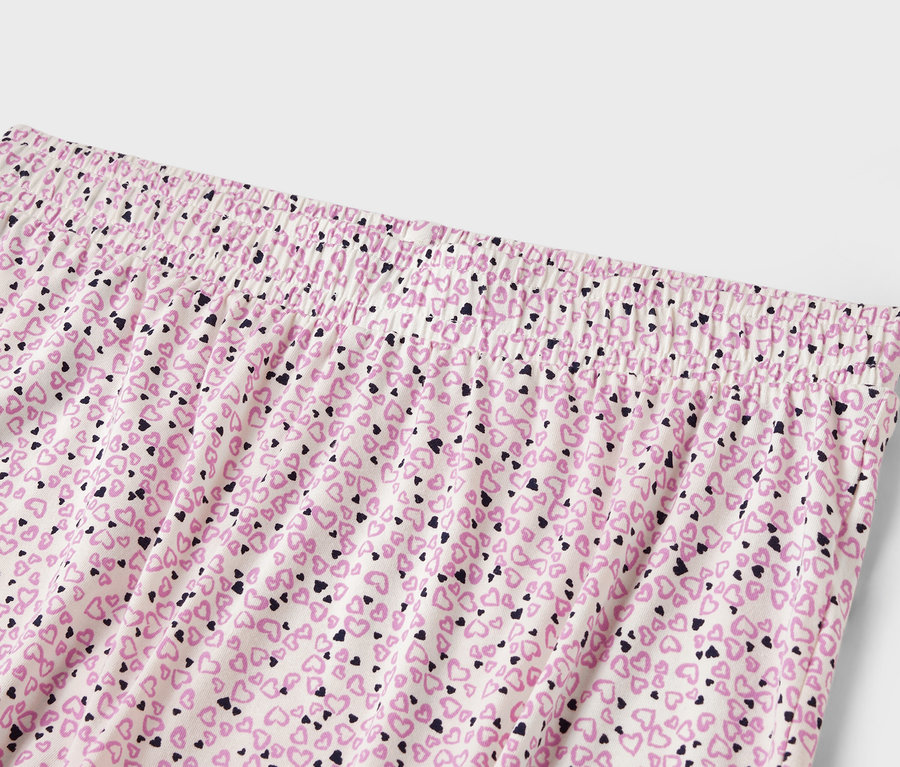 Détail d'un pantalon de femme avec une taille élastique et un imprimé all-over de petits cœurs.