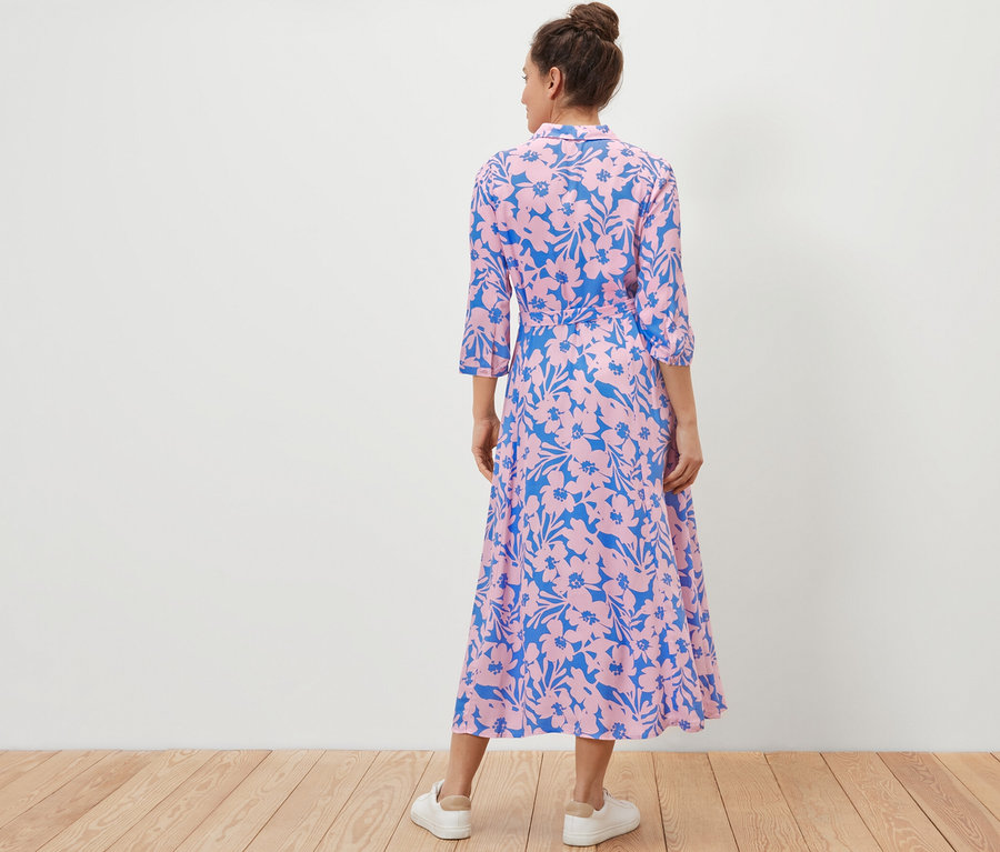 Femme vue de dos portant une robe chemise imprimée.