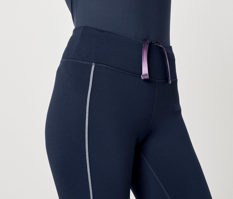Gros plan sur un legging de sport bleu marine pour femme avec un cordon de serrage violet.