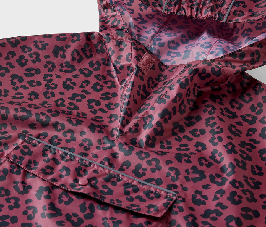 Détail d'un poncho de pluie rose pour enfant avec un imprimé intégral.