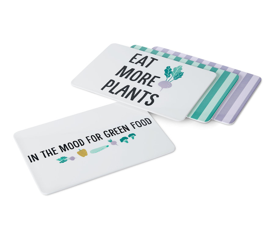 Quatre planches à découper avec différents motifs de légumes et inscriptions.