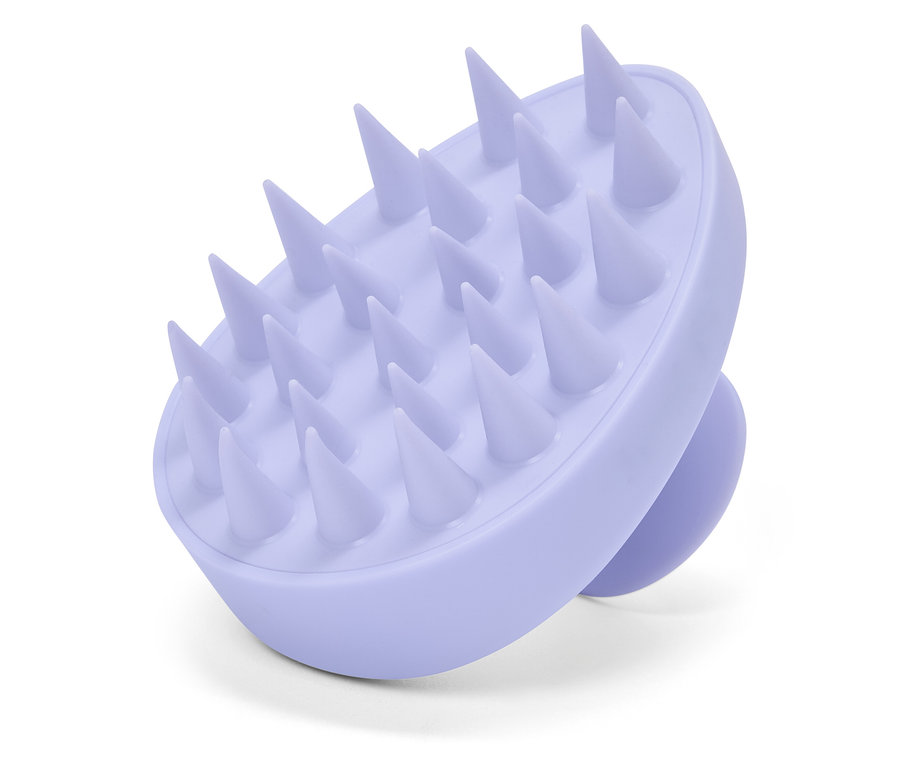 Gros plan d'une brosse de massage du cuir chevelu violette.