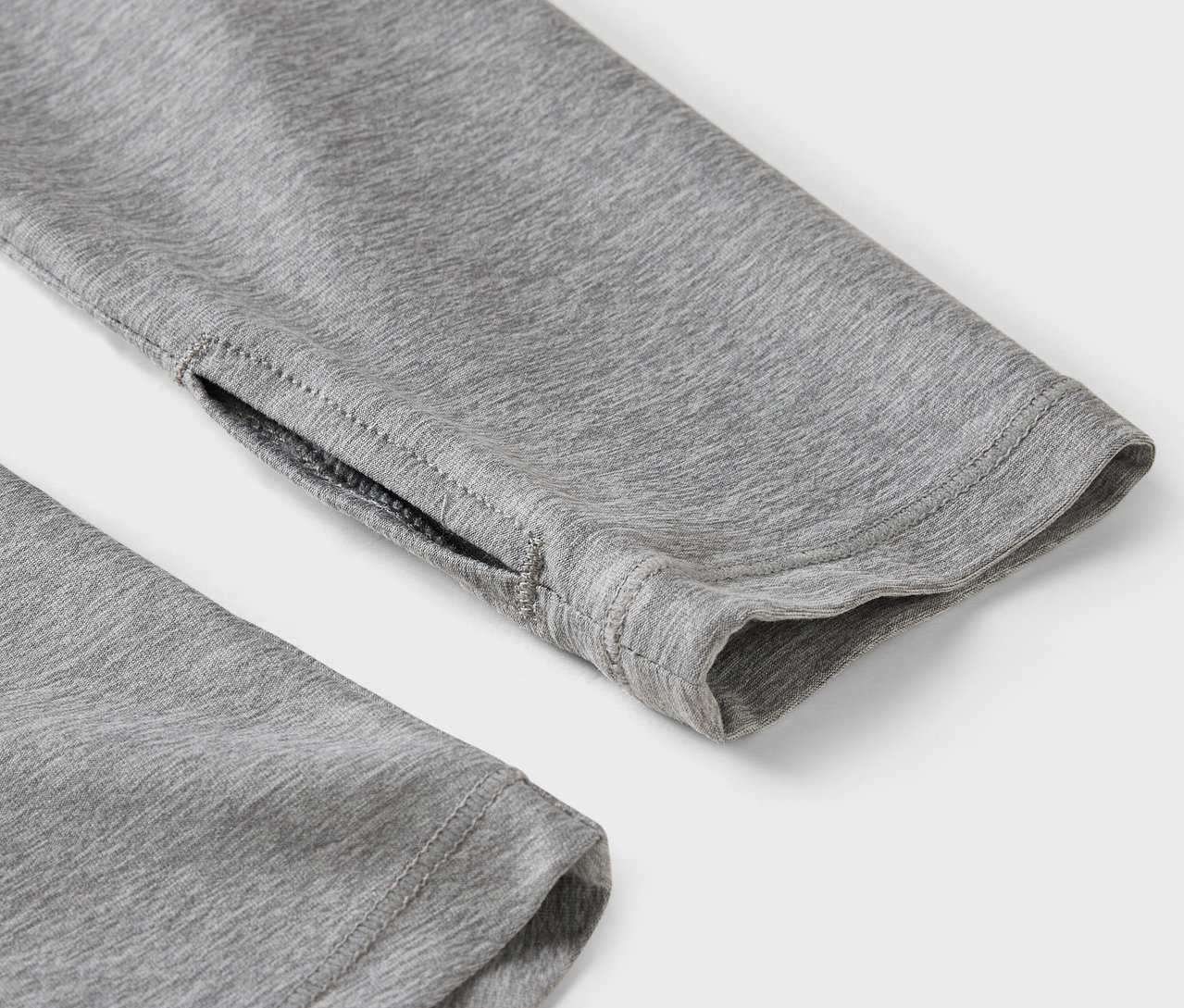 Gros plan sur la manche grise avec trou pour le pouce.