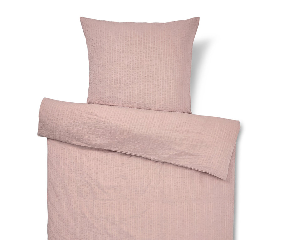 Linge de lit rose avec taie d'oreiller.