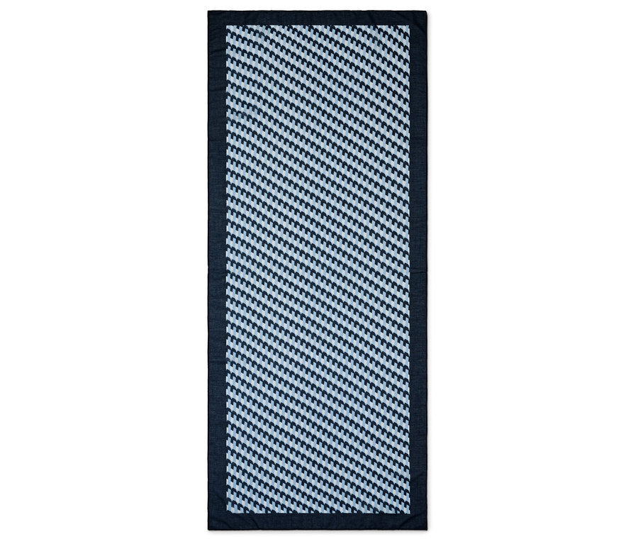 Tapis rectangulaire à motif géométrique bleu et blanc avec une bordure bleu foncé.